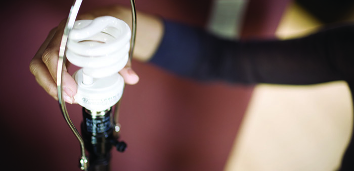 Woman changing light bulb