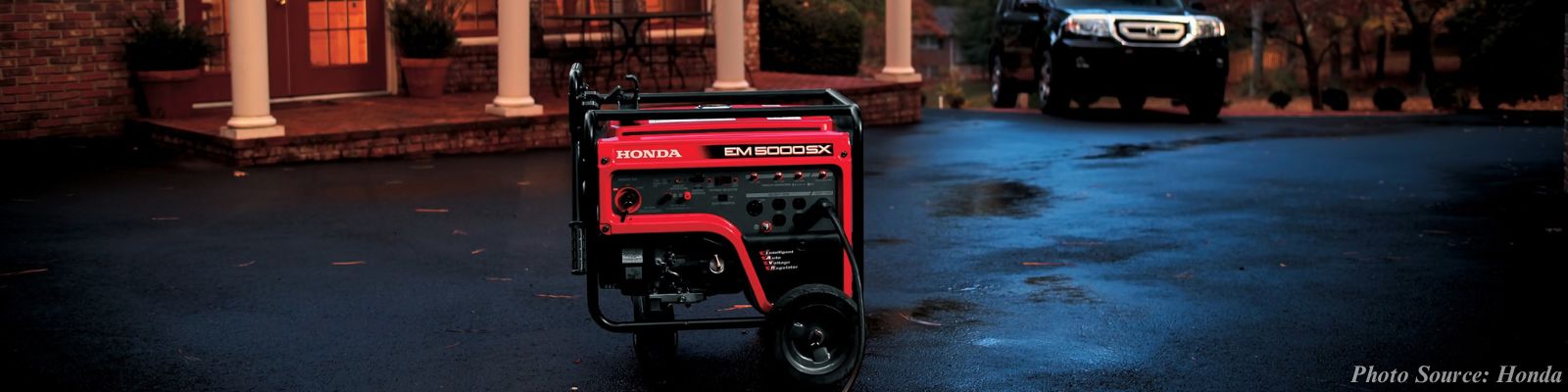 Portable generator with home and car in the background. 